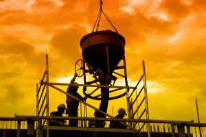 Silhouettes,Of,Construction,Workers,Pouring,Concrete,Mix,At,The,Building